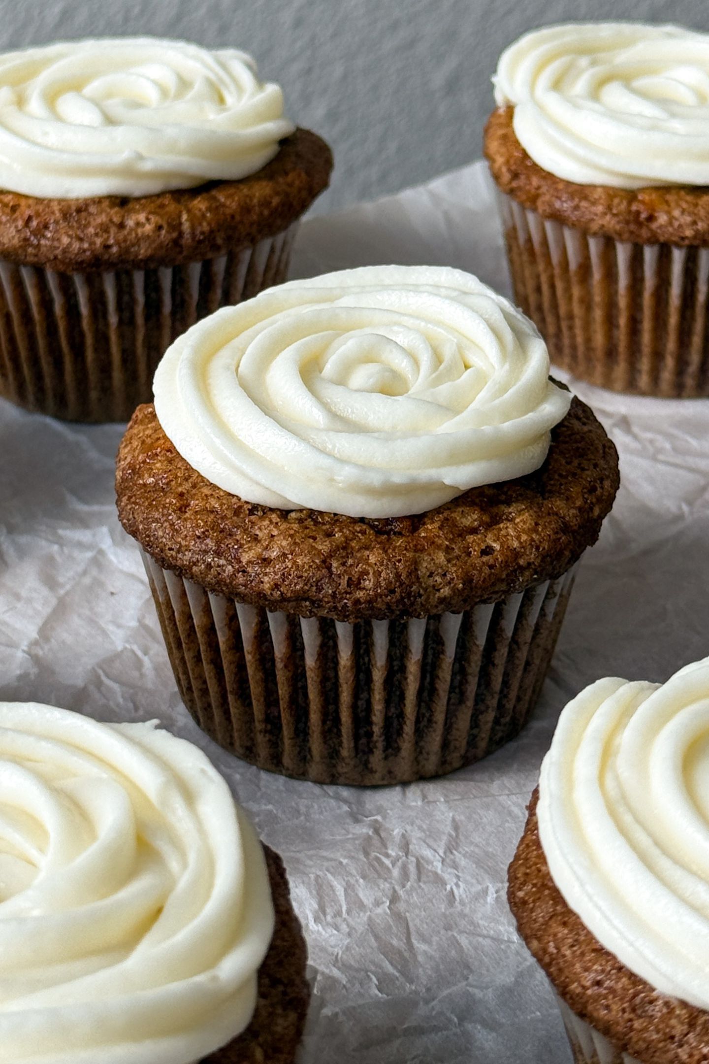 Carrot cake cupcake topped with a swirl of cream cheese frosting.