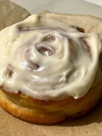 Protein Cinnamon Roll topped with a vanilla cream cheese frosting.