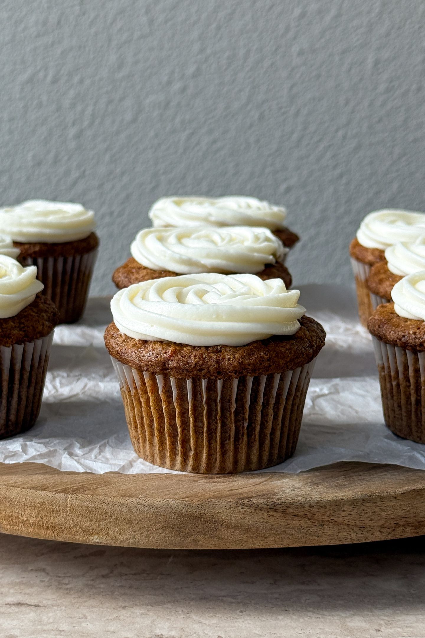 Frosted carrot cake cupcakes on a serving platter.