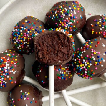 Fudgy Brownie Cake Pops on a platter with a bite taken out of one.