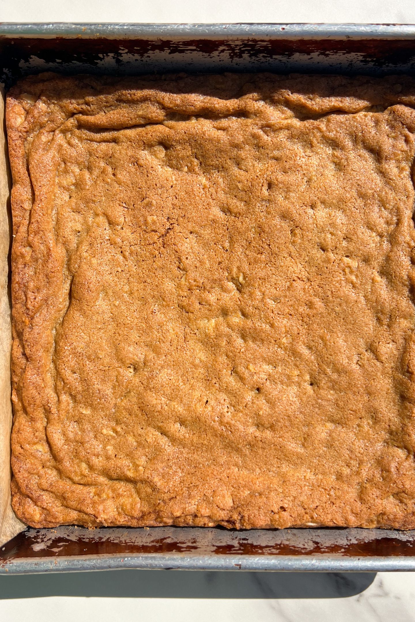 Baked oatmeal cookie base in pan.