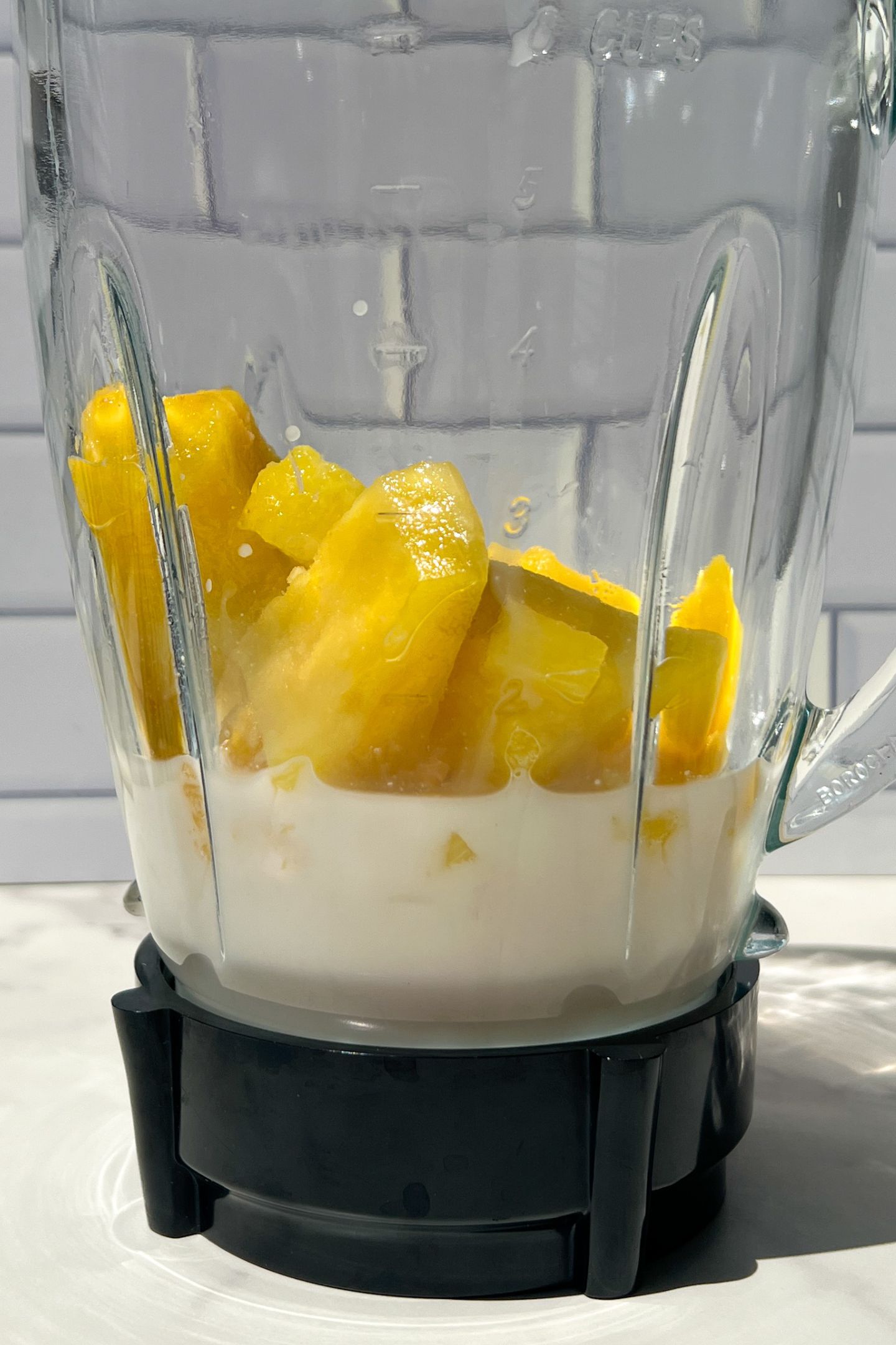 Liquid and frozen pineapple in blender.