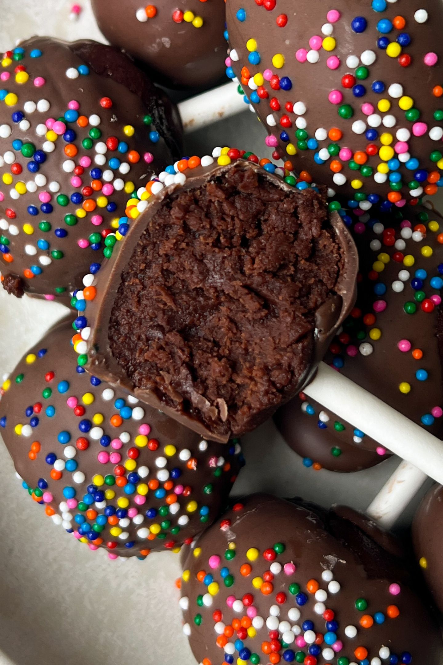 Brownie cake pop on a platter with a bite taken out of it.