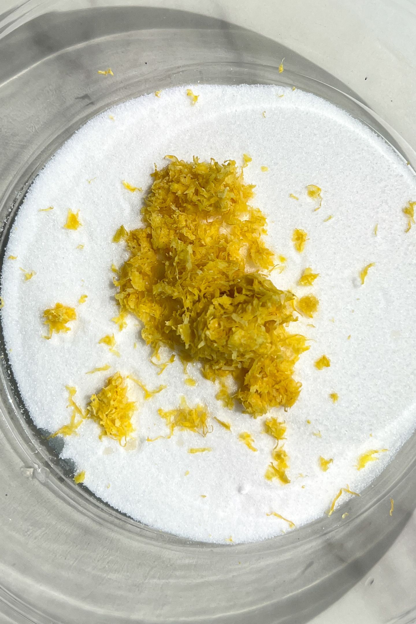 Granulated sugar and lemon zest in a bowl.