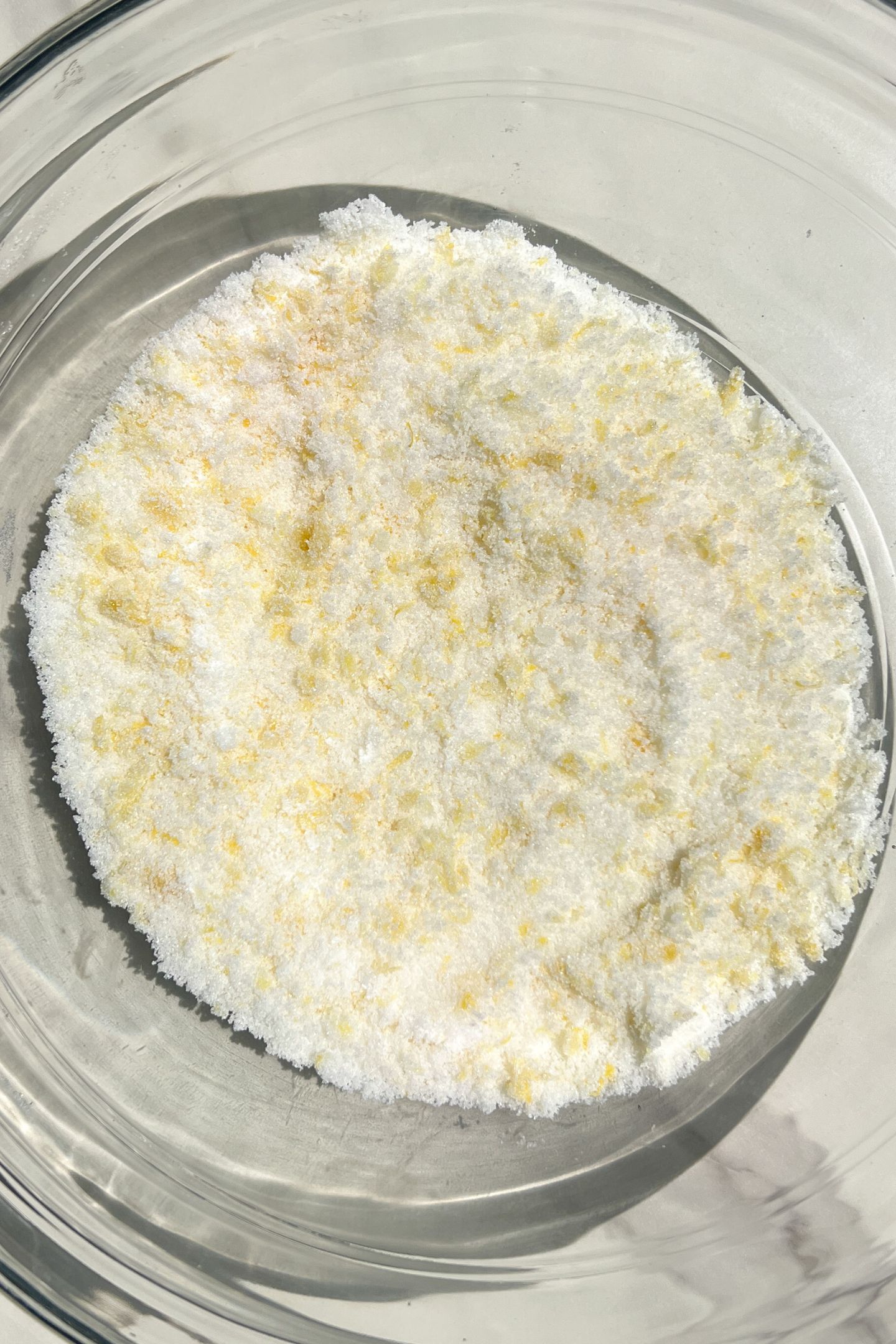 Granulated sugar and lemon zest in a bowl.
