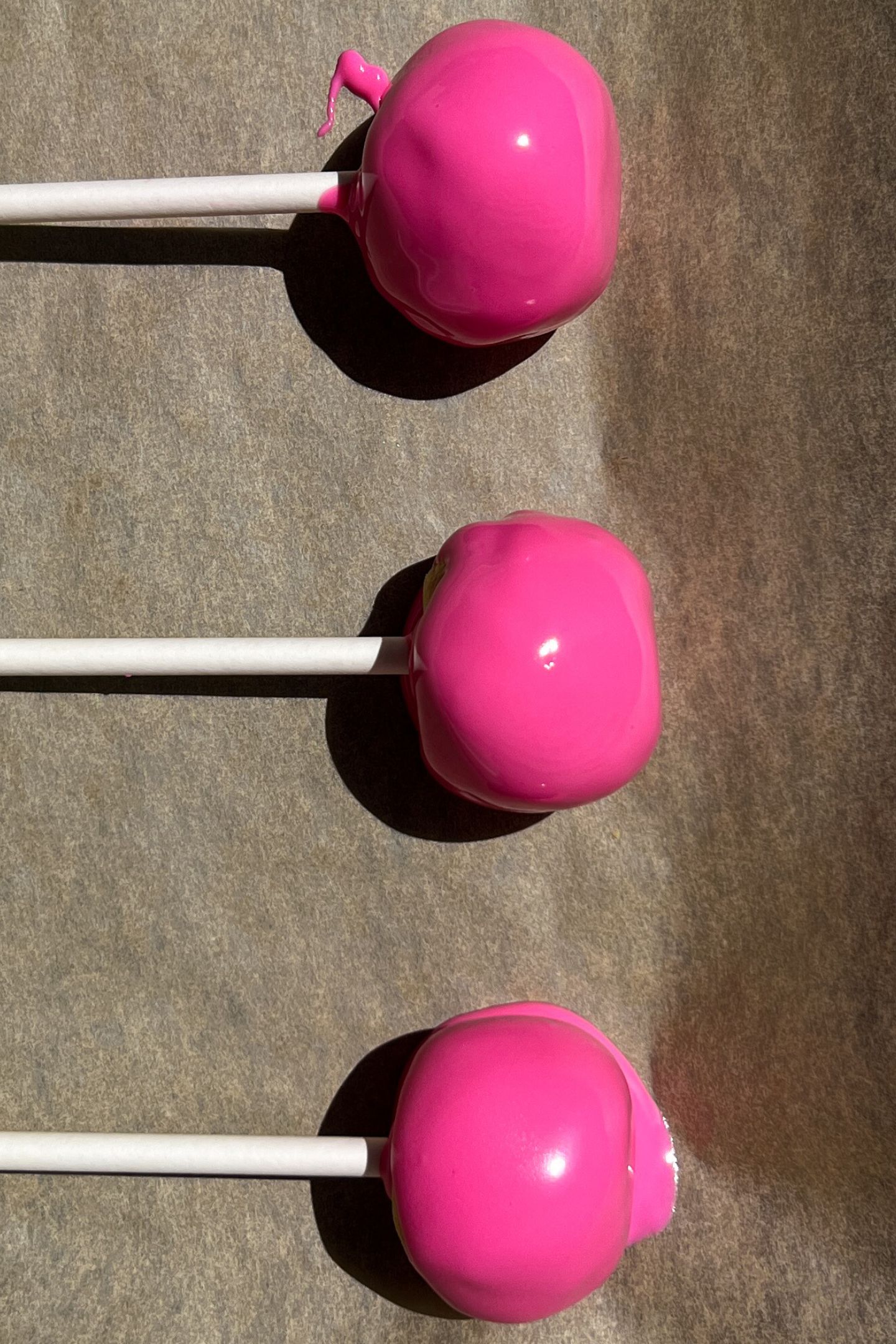 Cake pops on tray lined with parchment paper.