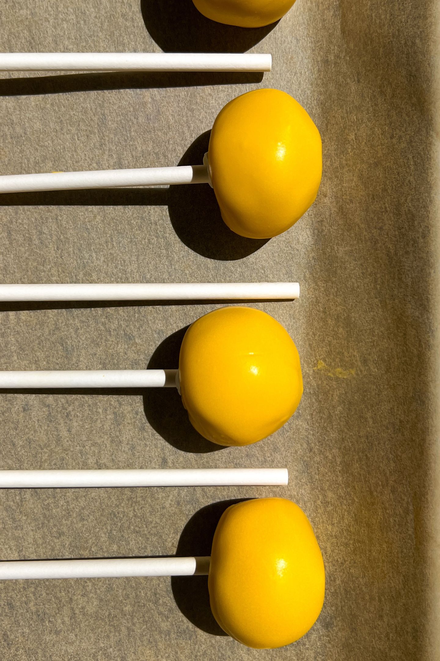 Cake pops on a baking sheet lined with parchment paper.