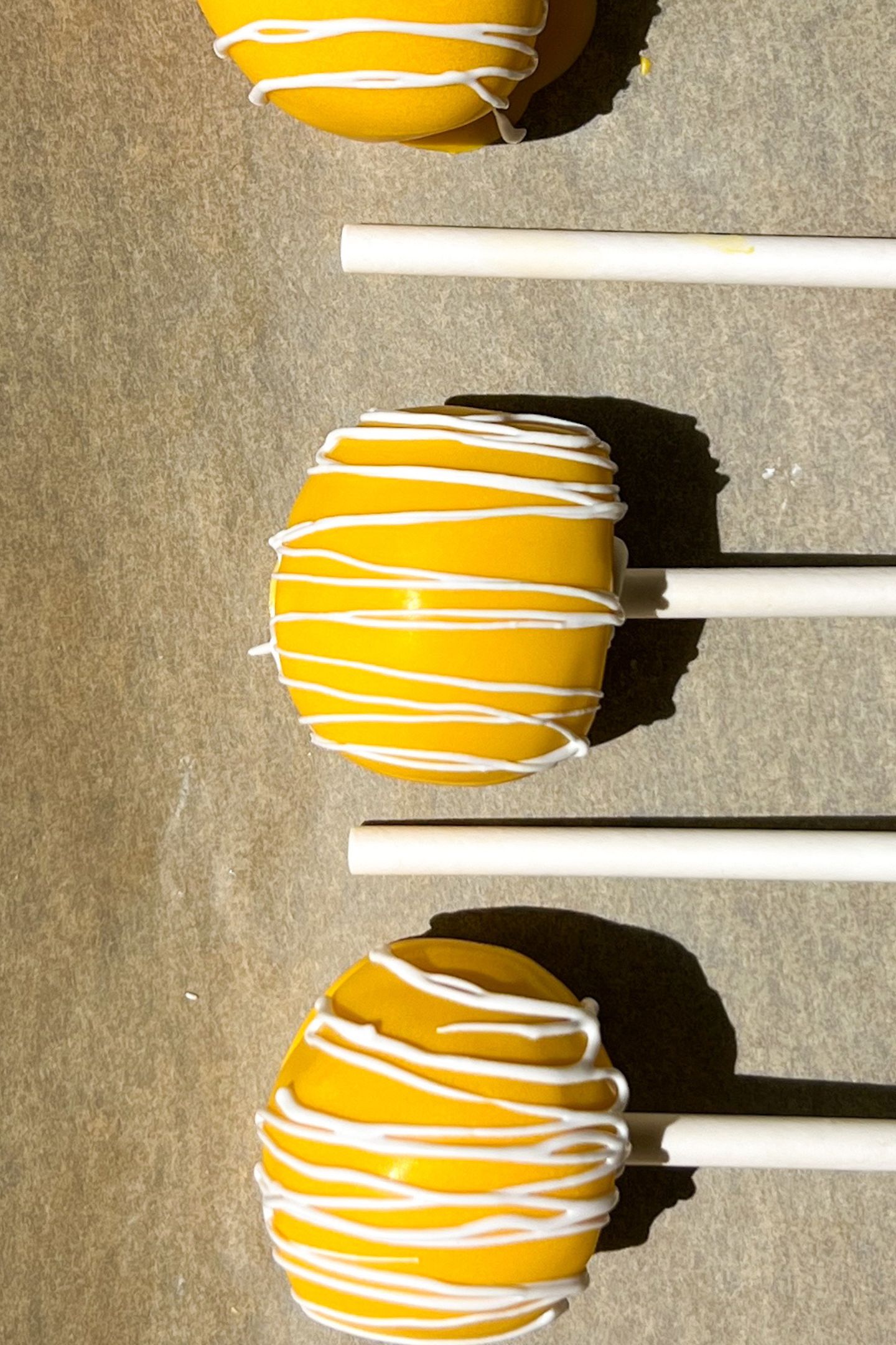 Decorated cake pops on a baking sheet lined with parchment paper.