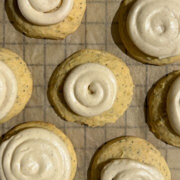 Lemon poppy seed cookies with frosting swirled on top.