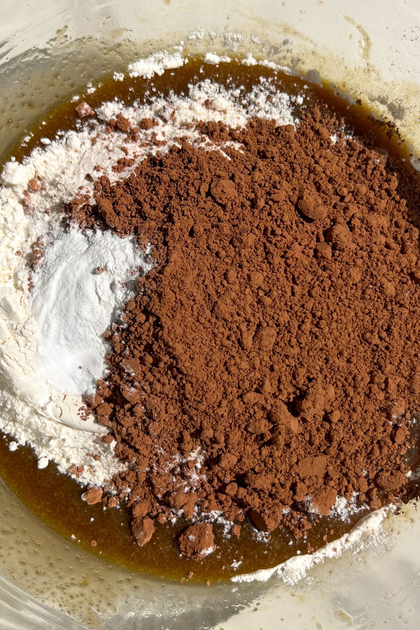 Adding dry ingredients to the wet in a bowl.