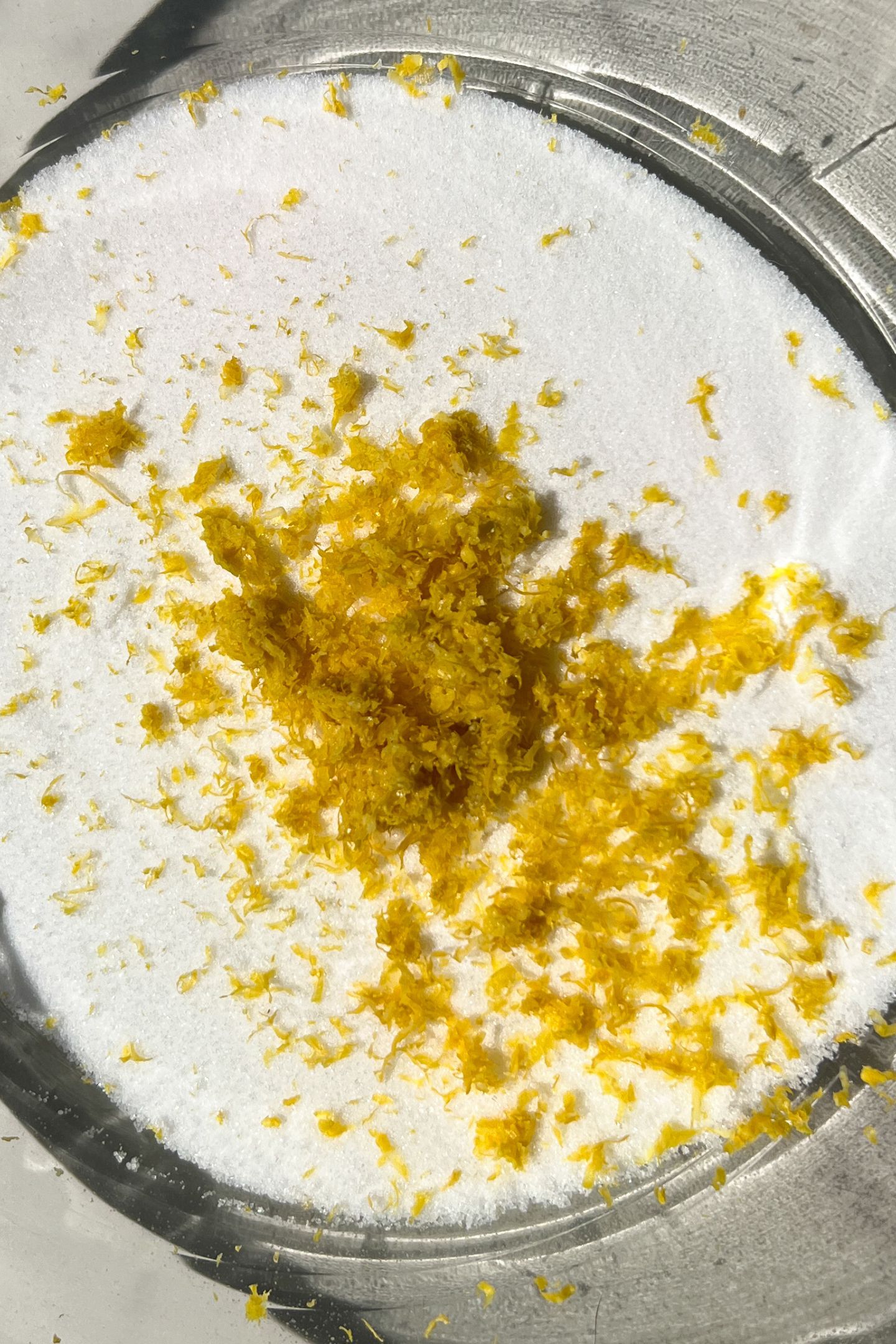 Lemon zest and granulated sugar in a mixing bowl.