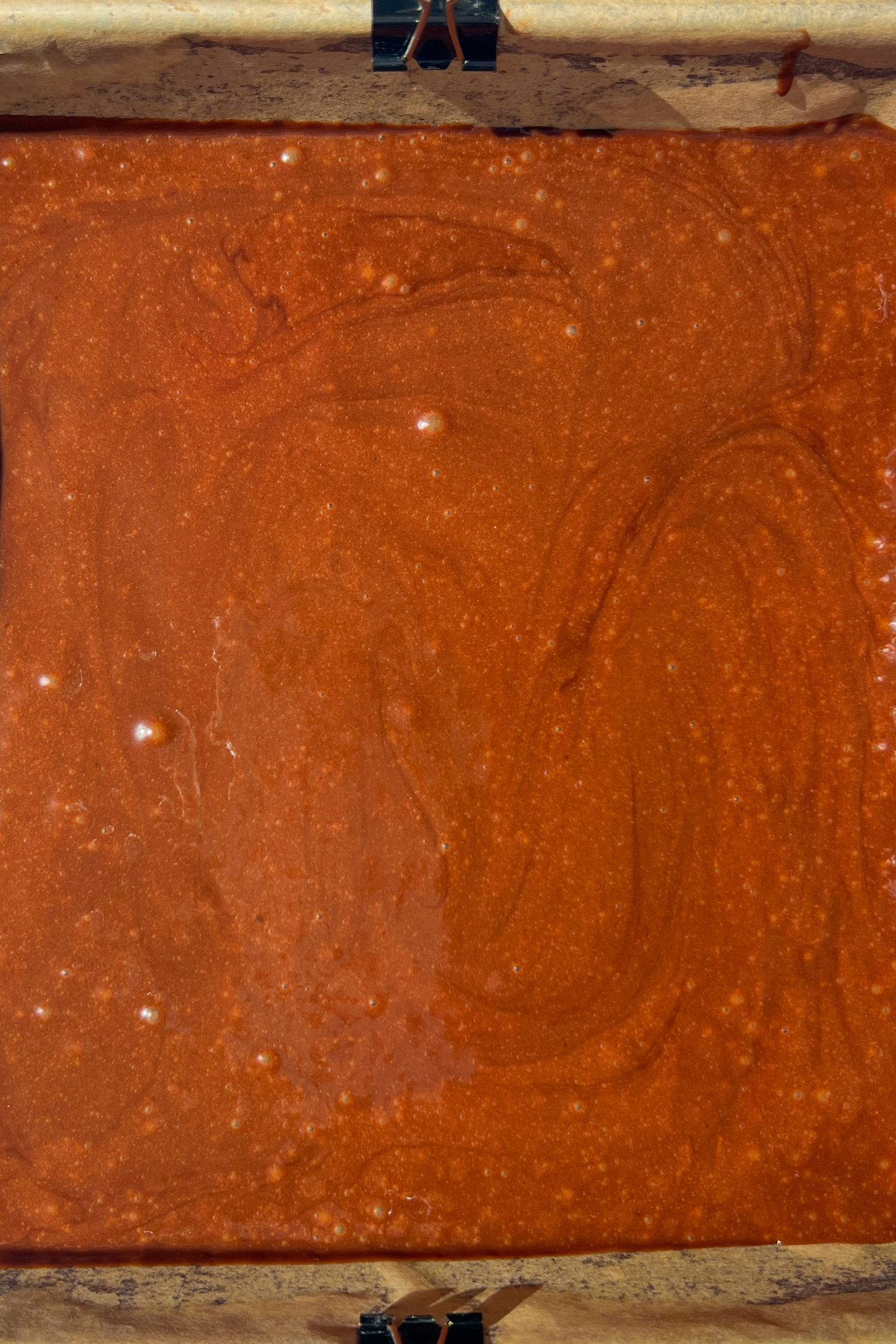 Chocolate cake batter in a prepared baking pan.