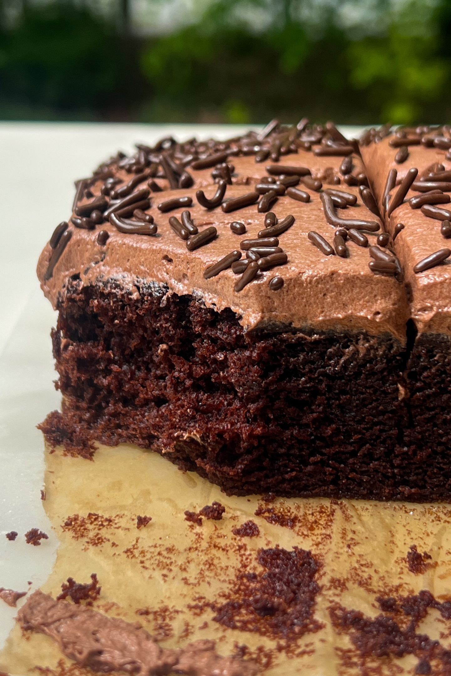 A slice of frosted chocolate cake with a bite taken out.