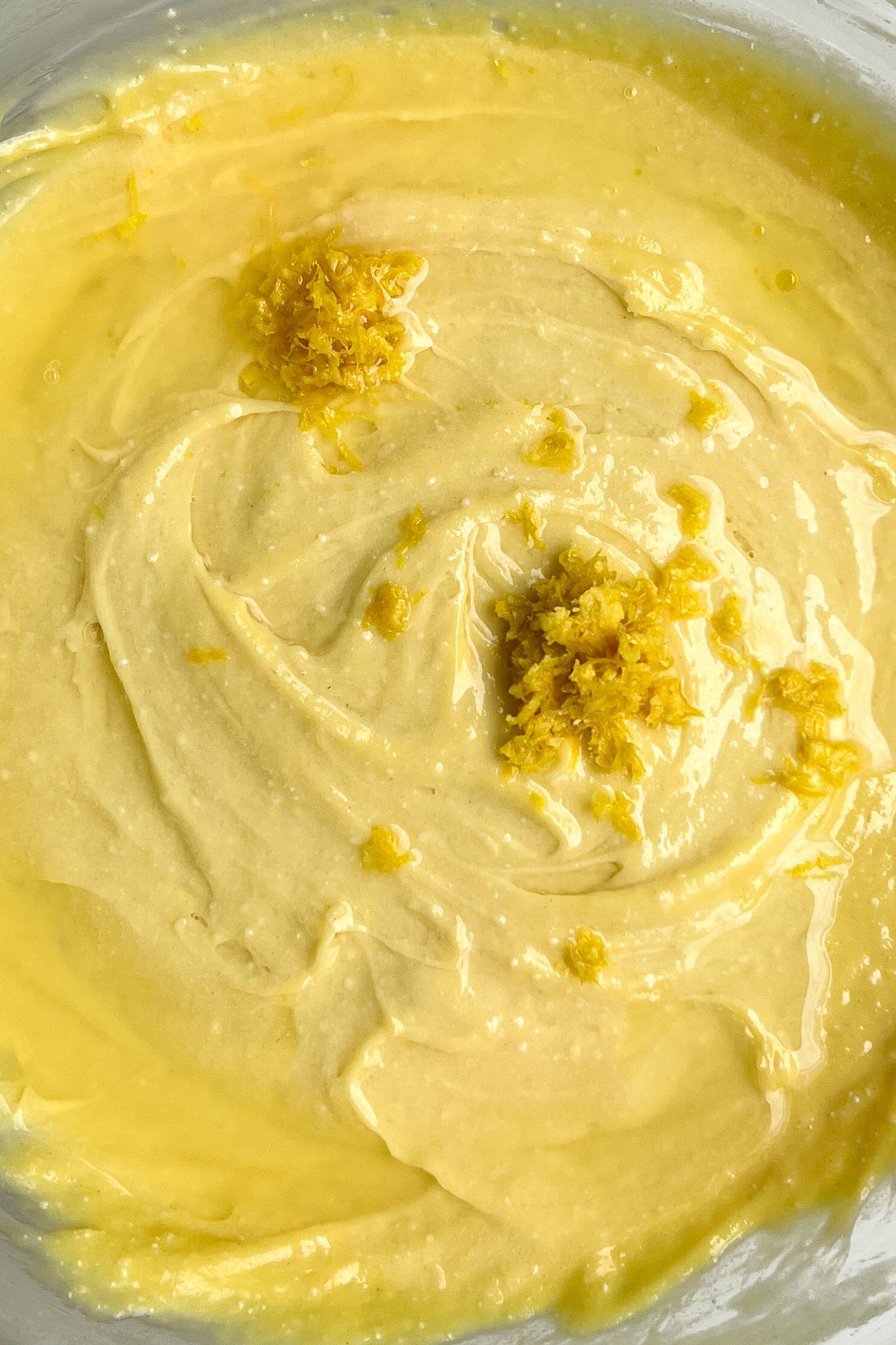 Cake batter with lemon zest in bowl.