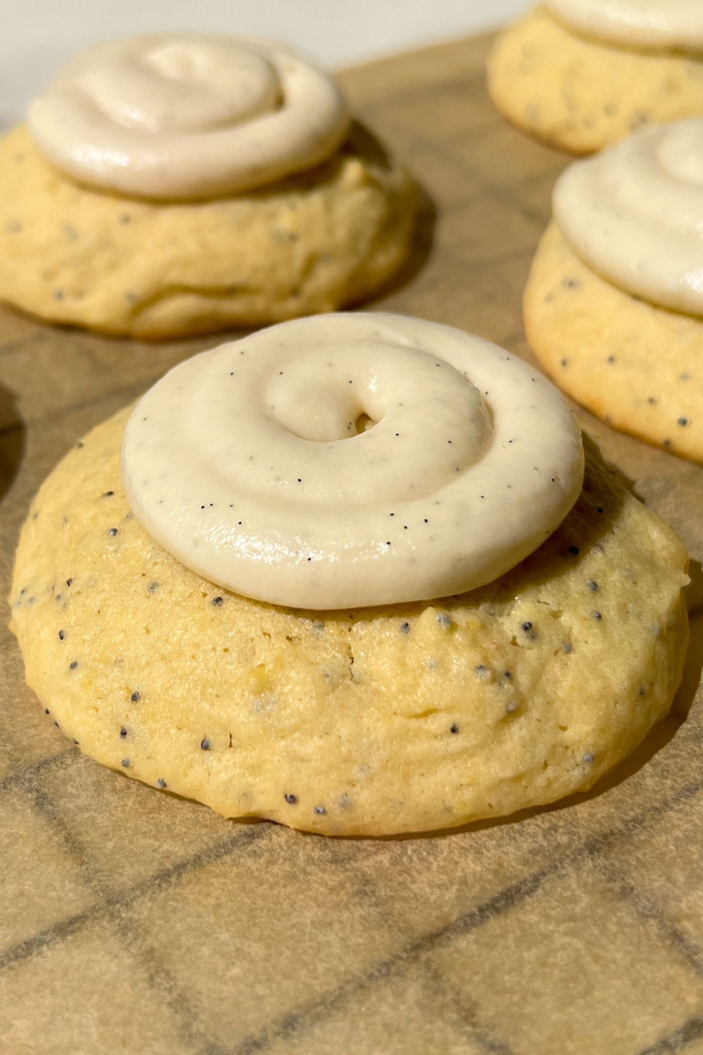 Side view of a frosted lemon poppy cookie.