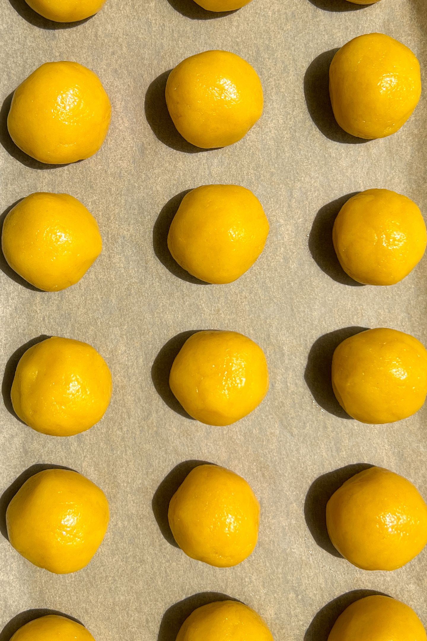 Formed cake pop balls on a baking sheet lined with parchment paper.