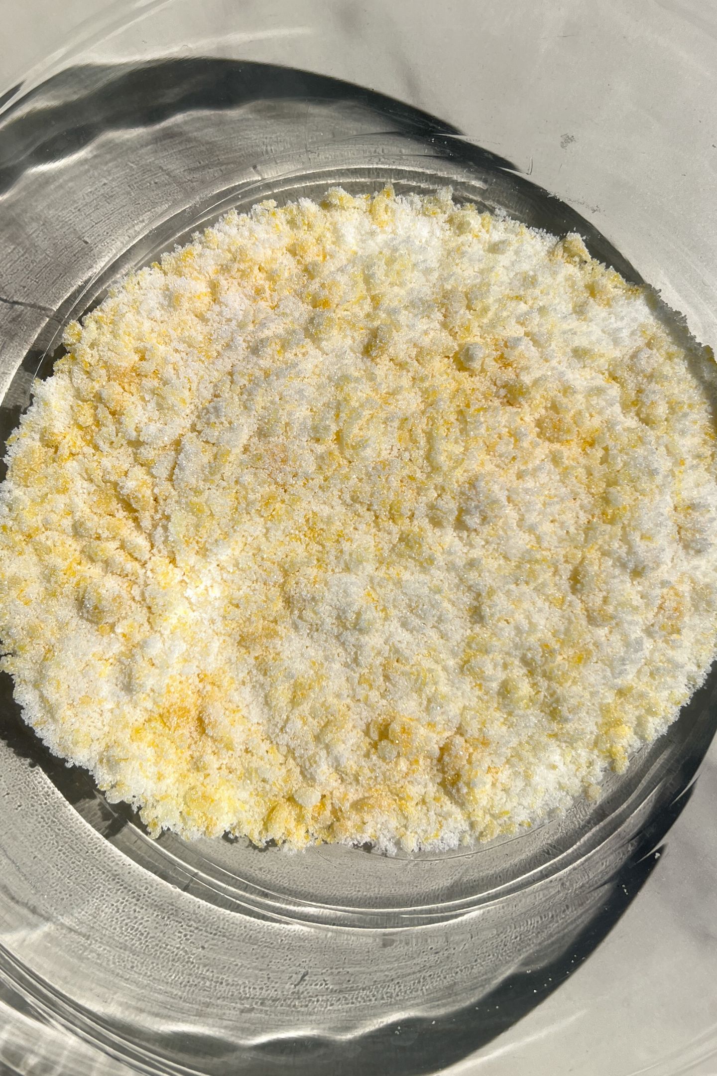 Lemon zest and granulated sugar mixed together in a bowl.