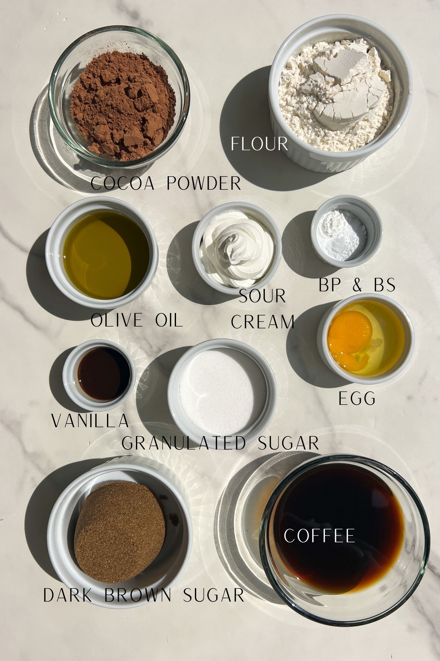 Cake ingredients measured out in bowls with labels.