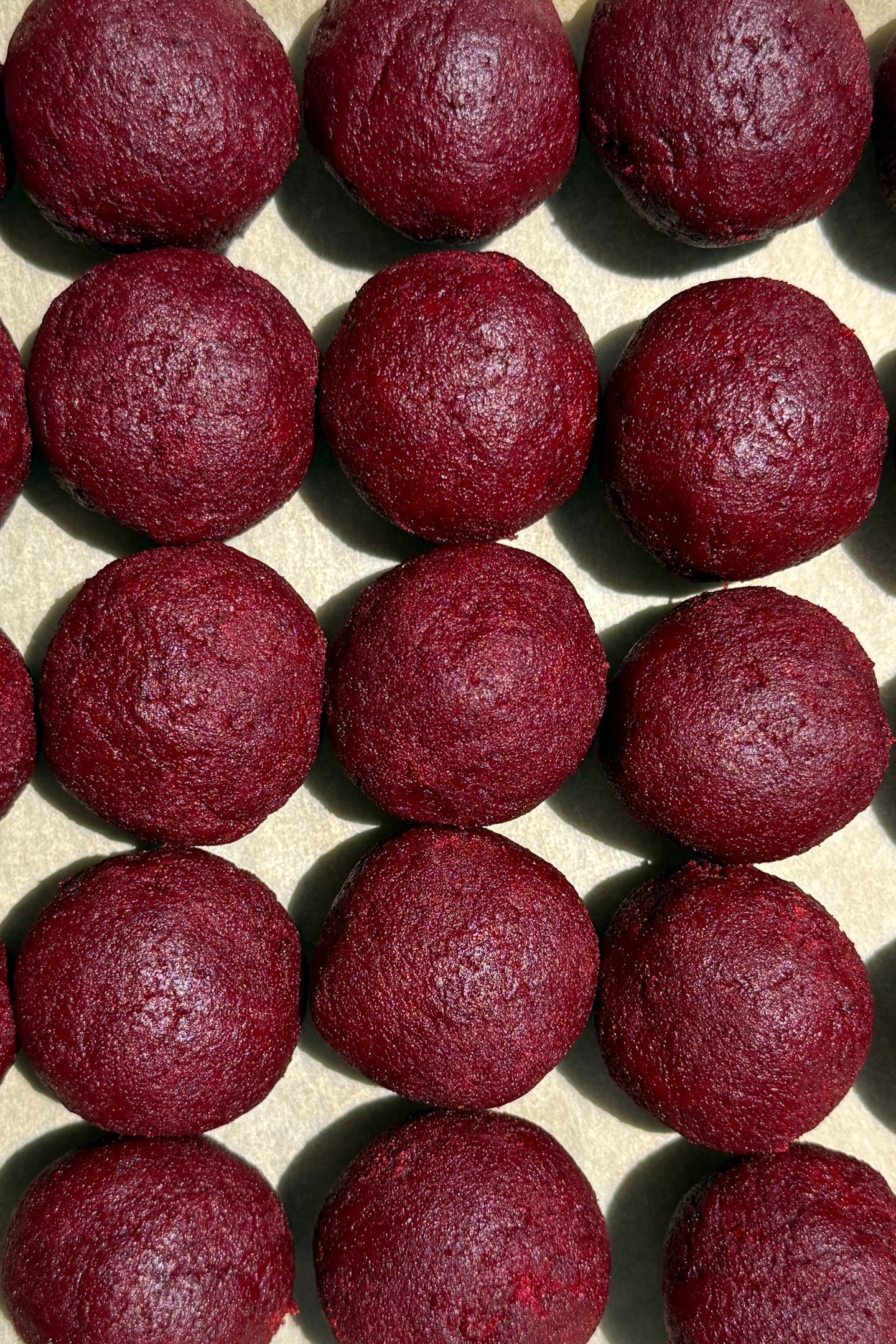 Cake pop balls formed on parchment paper.