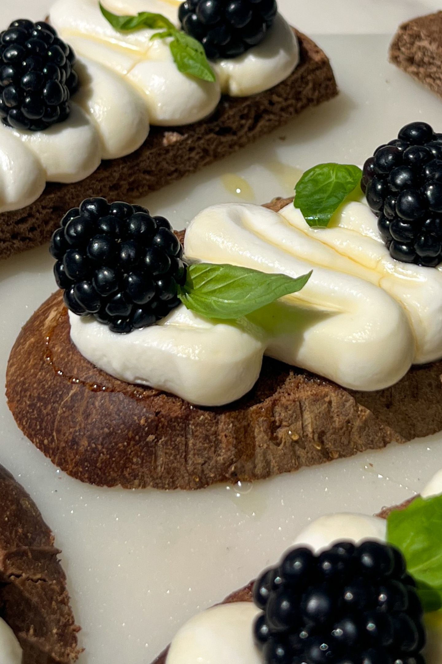 Pumpernickel bread topped with goat cheese, blackberries, honey and basil.