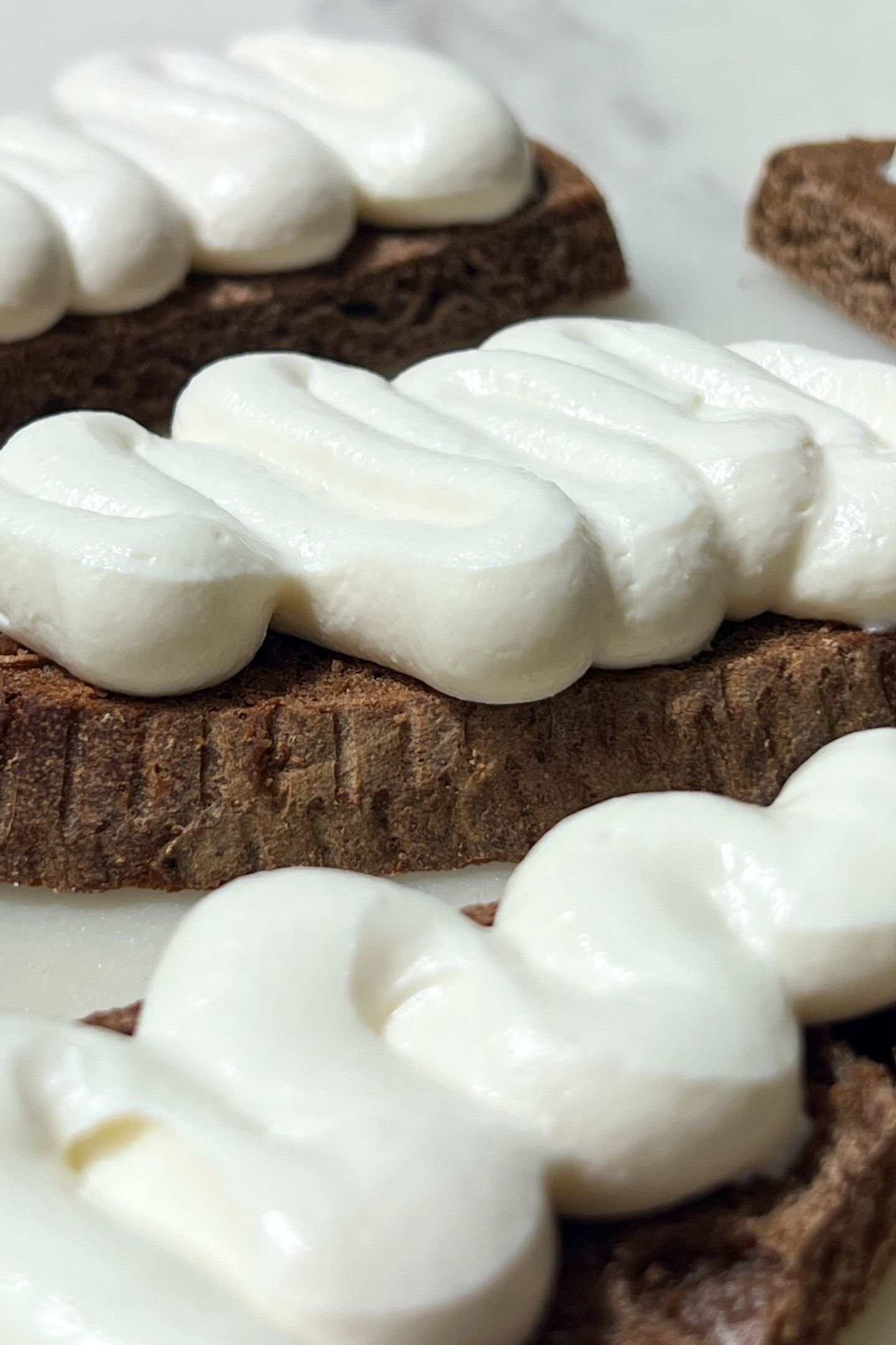 Crostini on a serving platter topped with goat cheese.