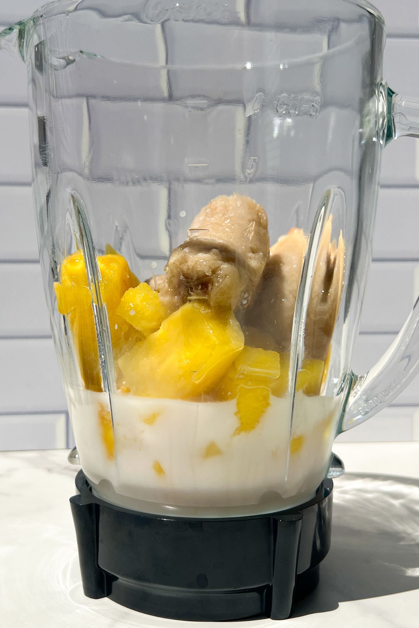 Liquid and frozen fruit in blender.