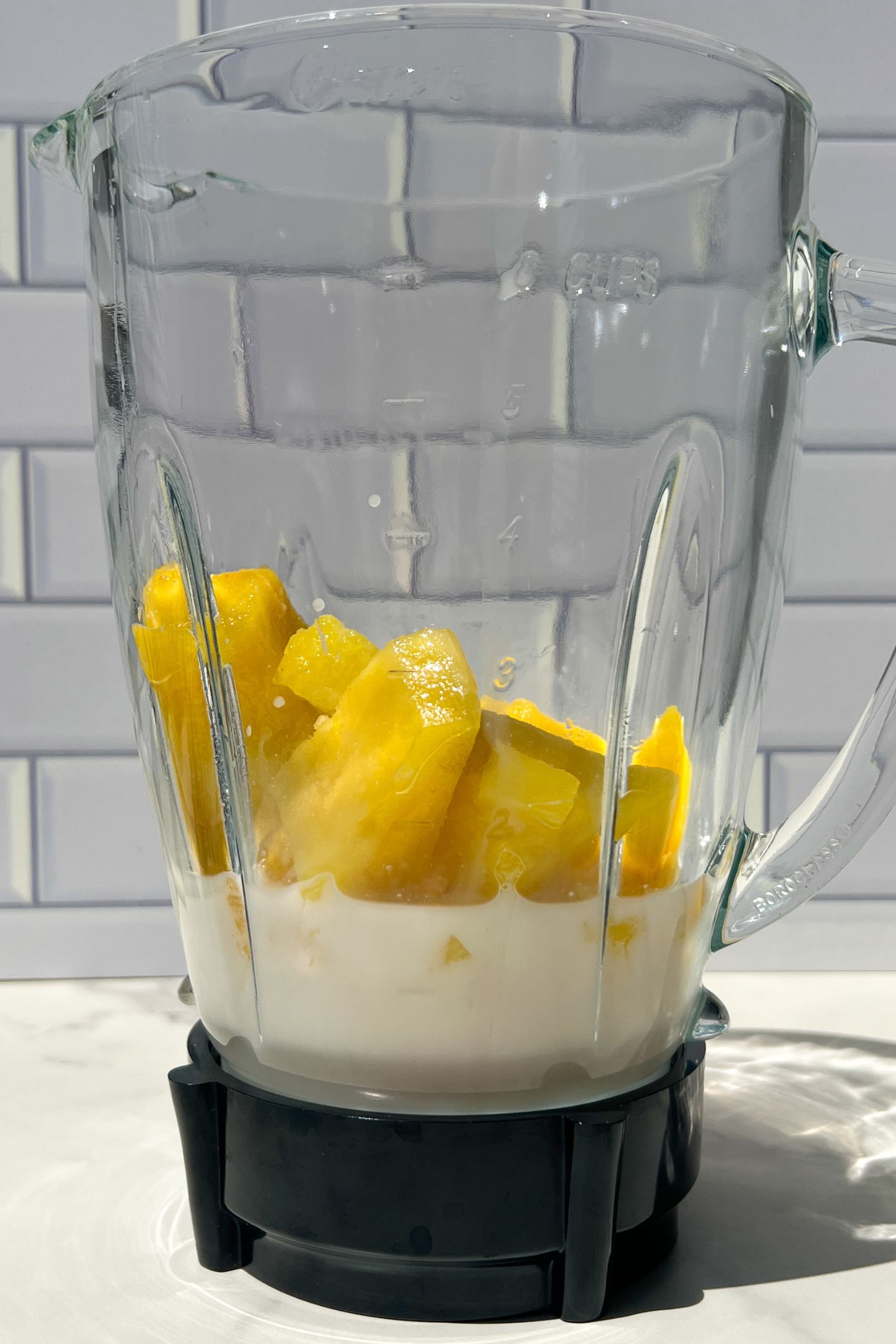 Liquid and frozen pineapple in blender.