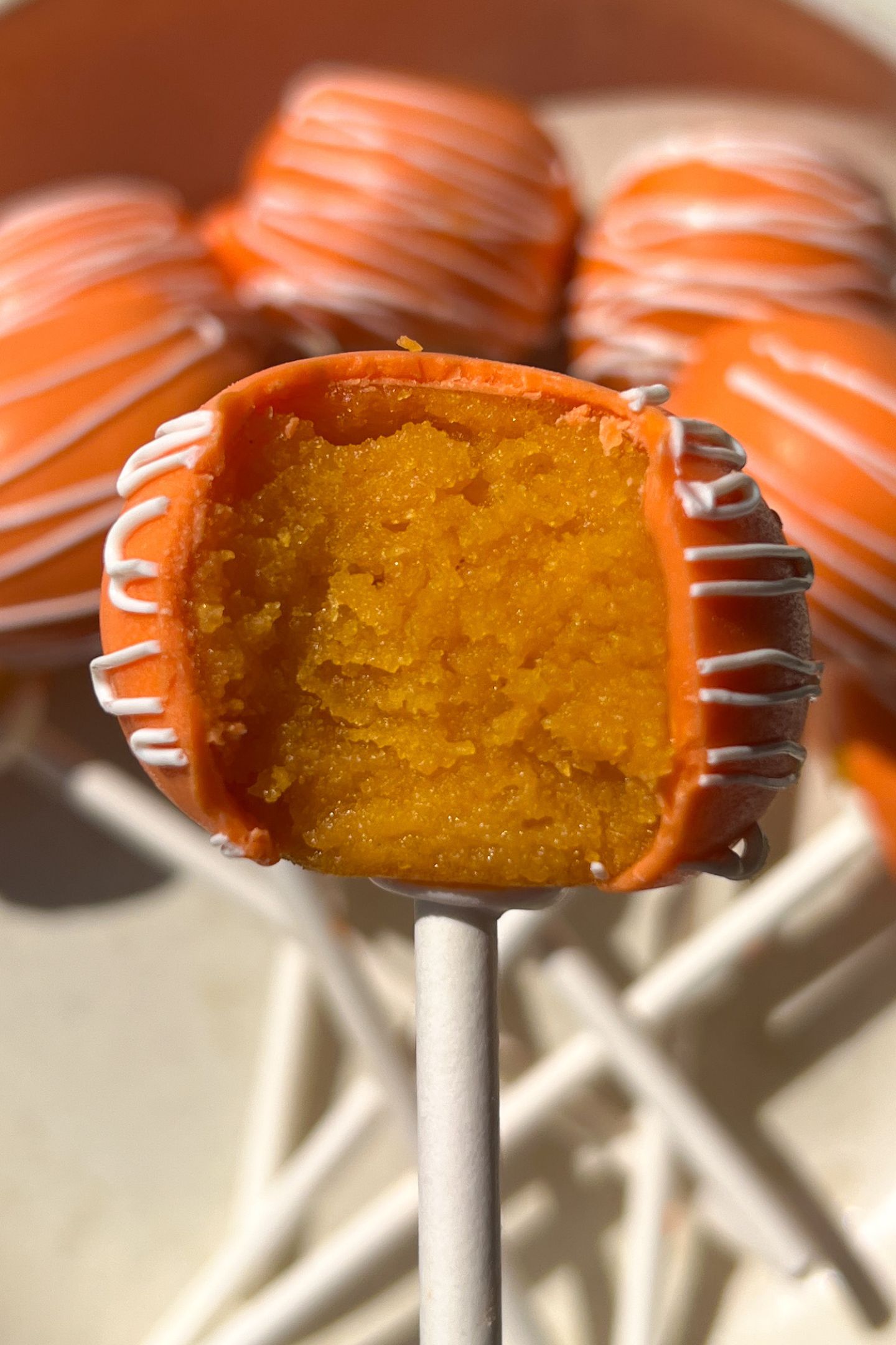 Cake pop on a stick with a bite taken out.