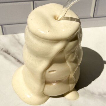 Pina Colada Smoothie in a glass with a straw.