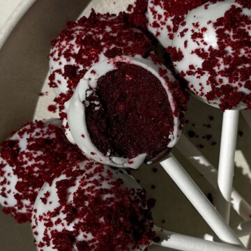Cake pops on a platter with one having a bite taken out of it.