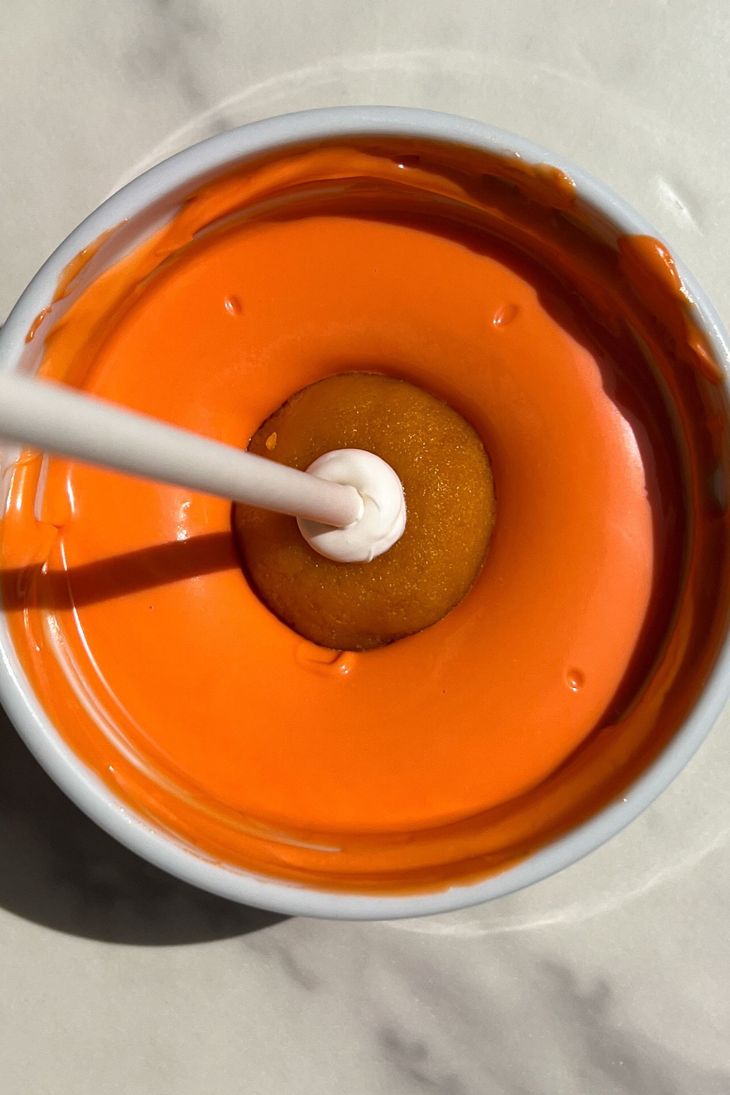 Dipping a cake pop in chocolate.