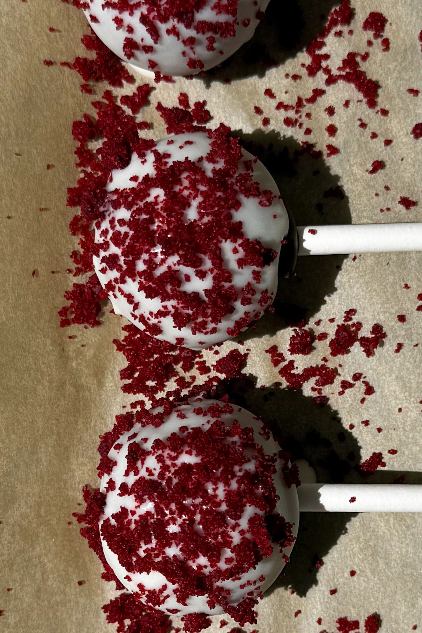 Cake pops coated in chocolate on parchment paper.
