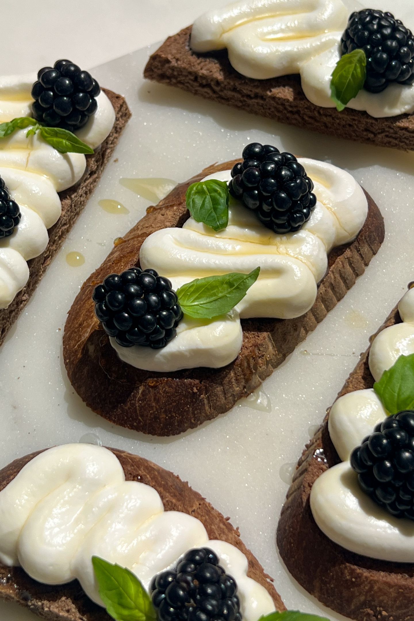 Goat cheese crostini topped with fresh blackberries and fresh basil.