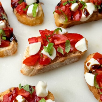Caprese Crostinis with Balsamic Glaze on a serving platter.