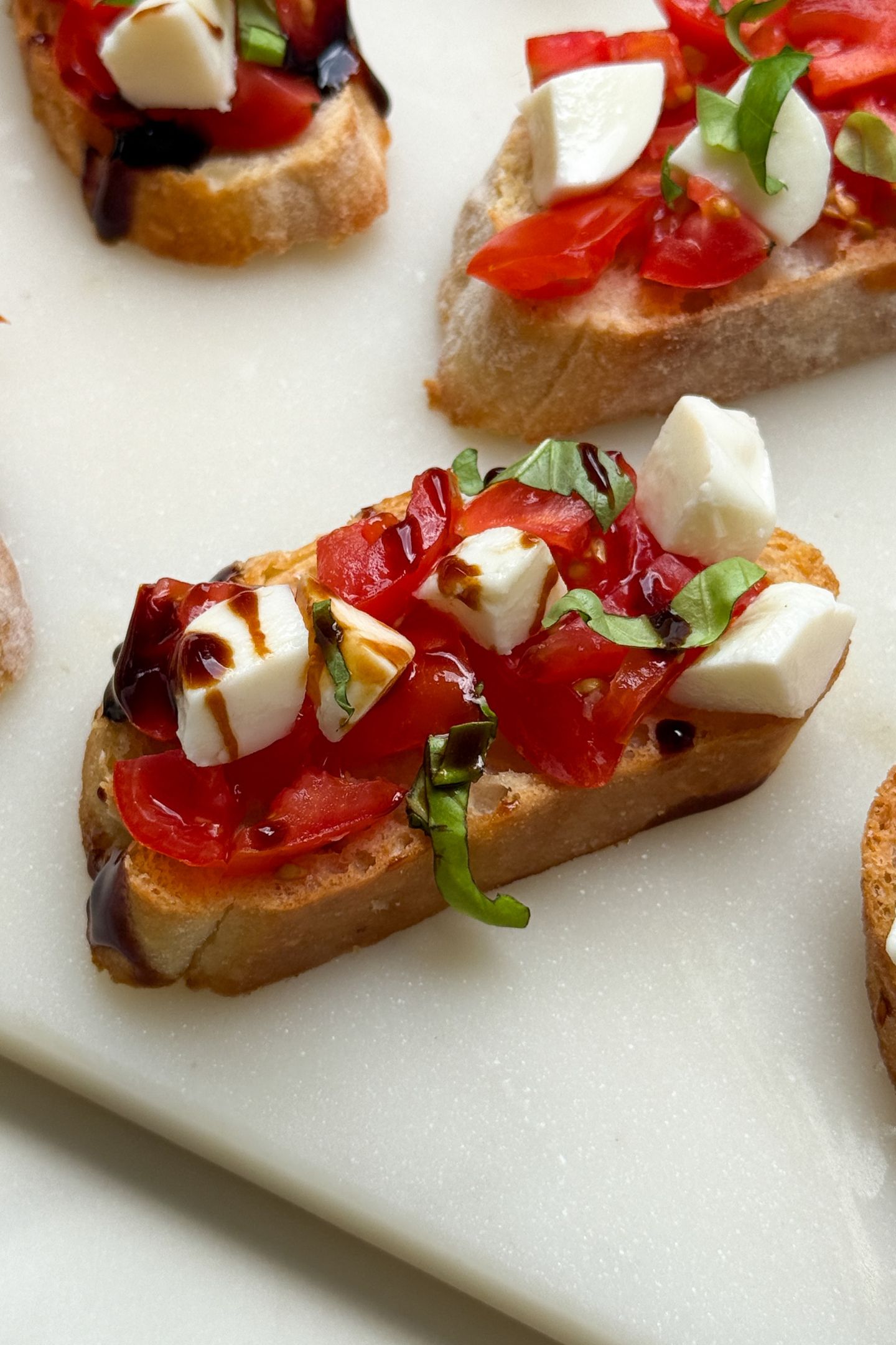 Crostini appetizer topped with mozzarella, tomatoes and basil.