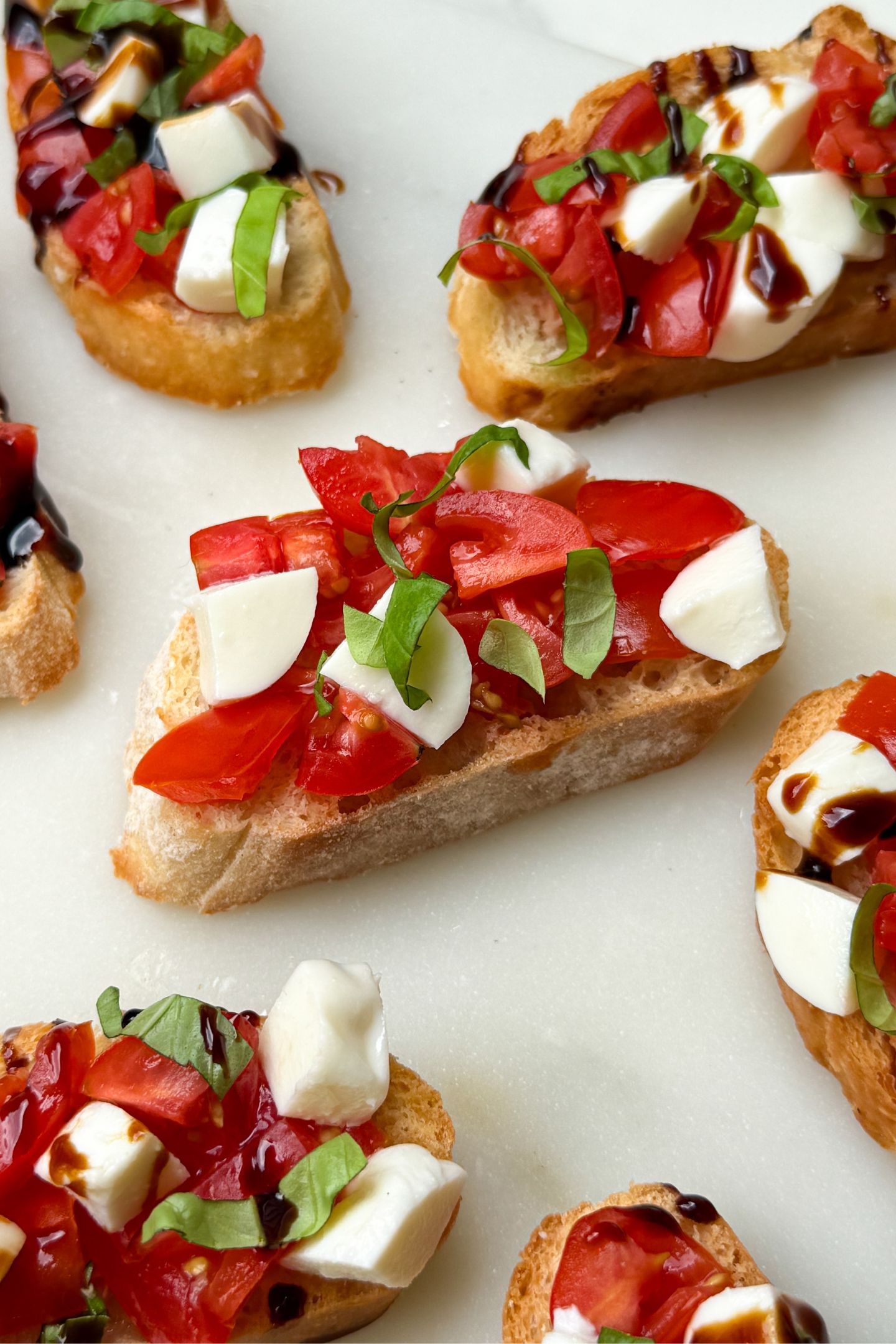Caprese Crostinis topped with tomato, mozzarella and balsamic.