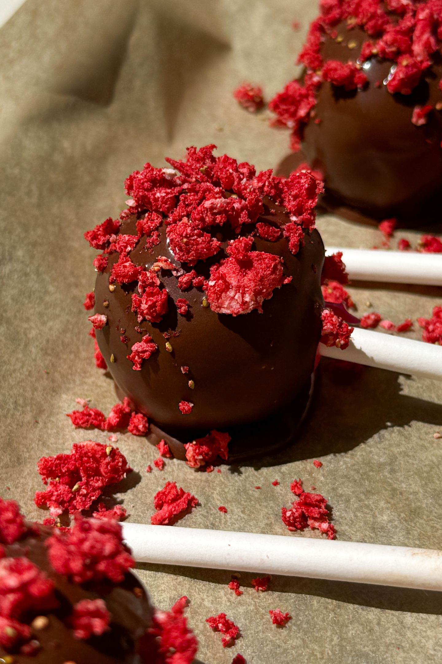 Cake pops decorated on parchment paper.
