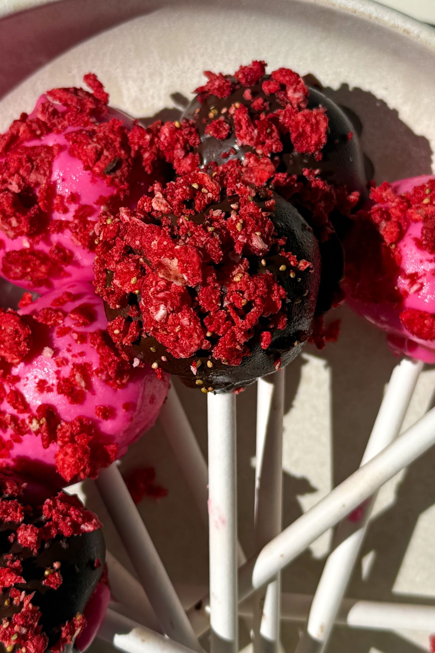 Strawberry cake pops on a platter.
