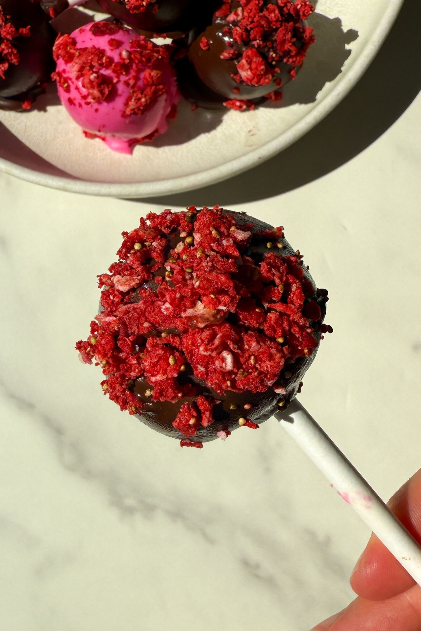 Holding a cake pop in my hand.