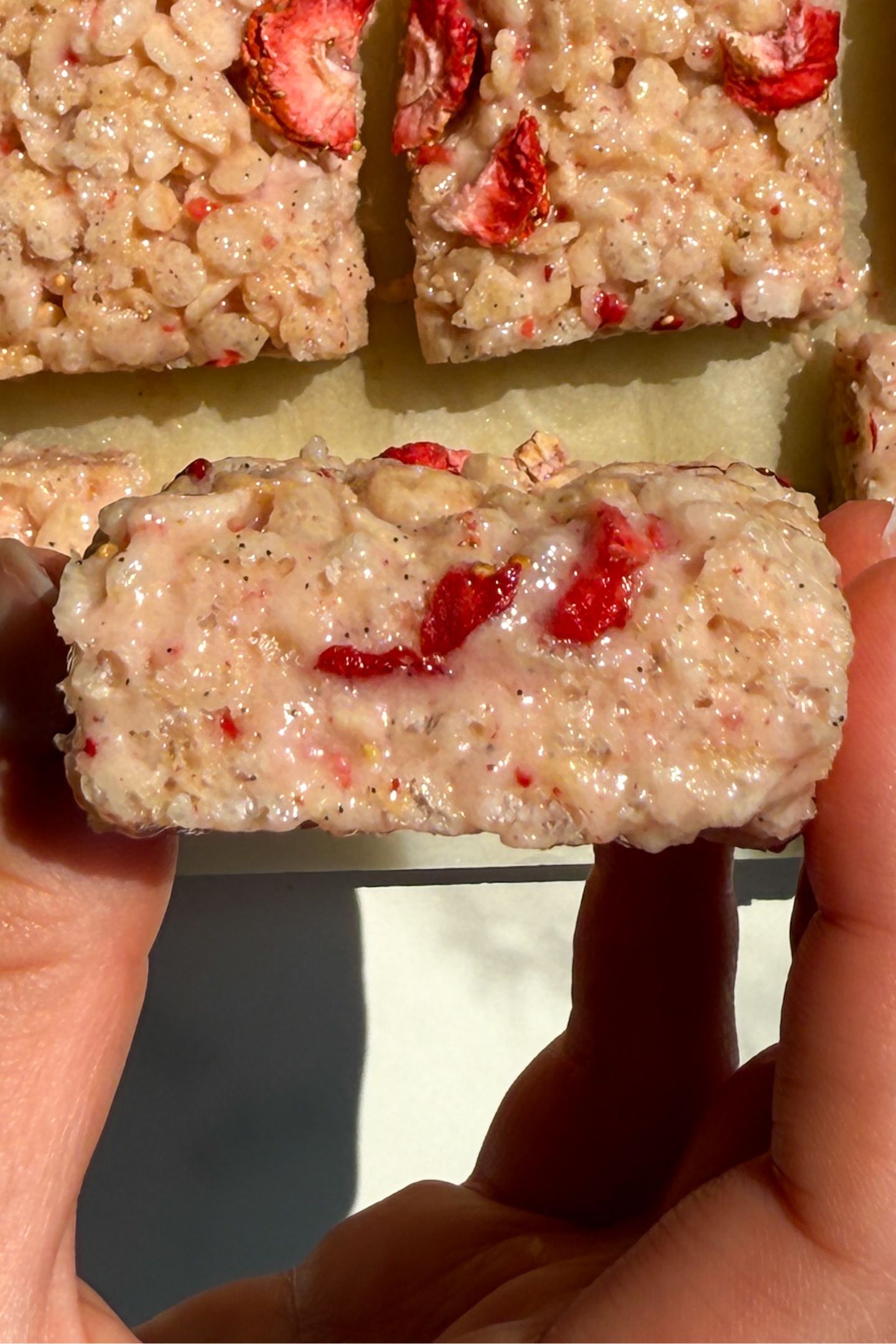 Holding a Rice Krispie Treat with freeze-dried strawberries in hand.