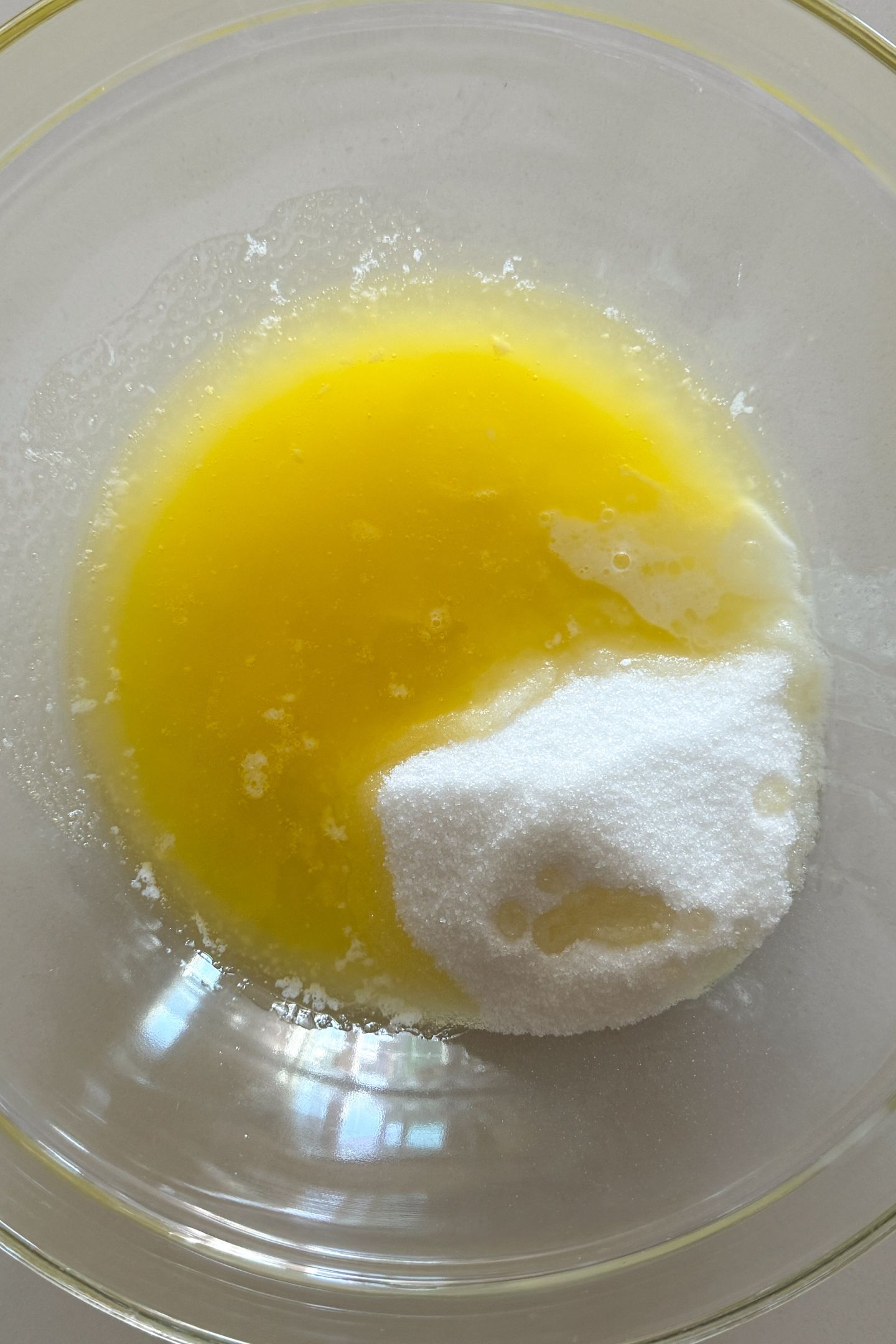 Melted butter and granulated sugar in a bowl.