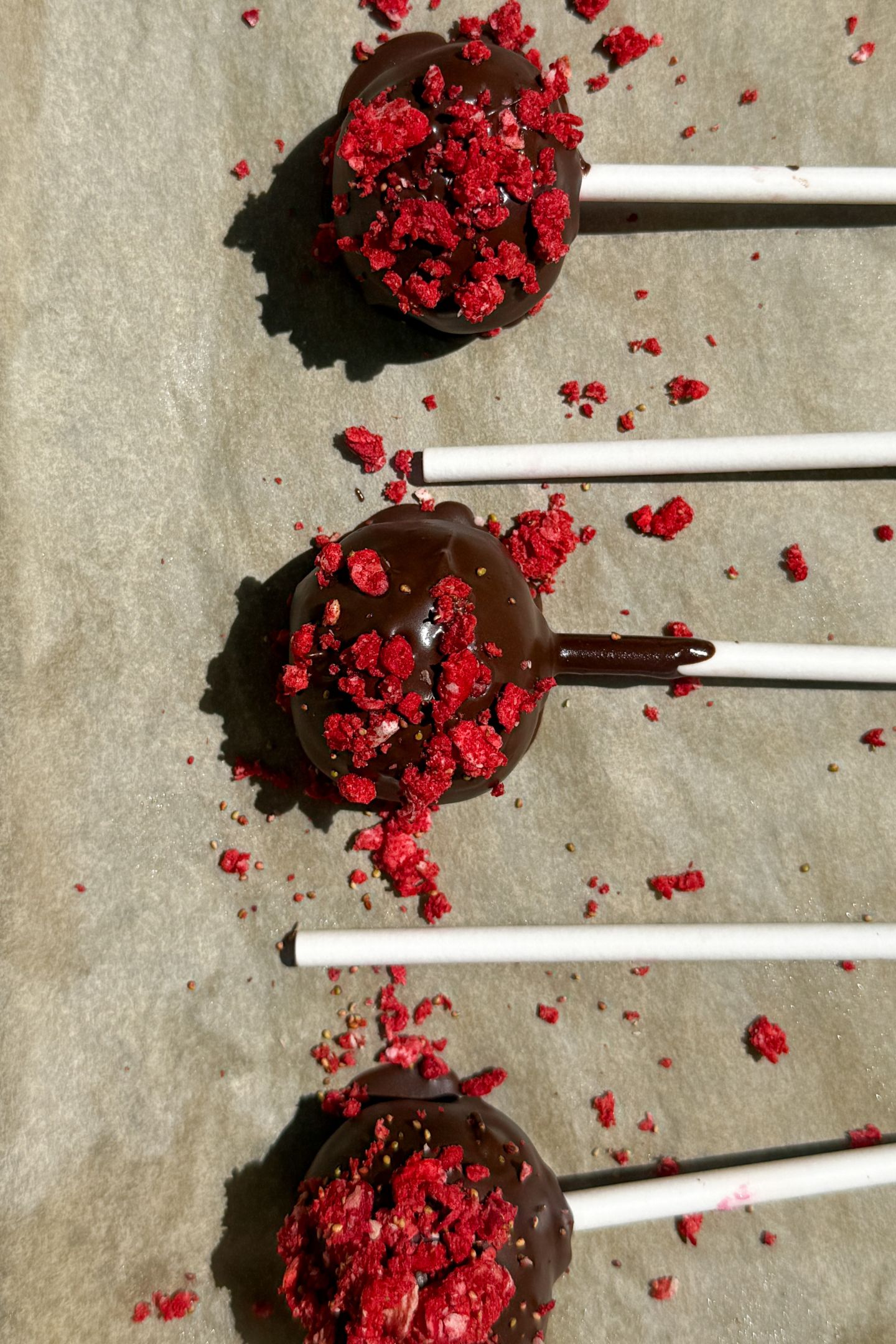Decorating cake pops with freeze-dried strawberries.