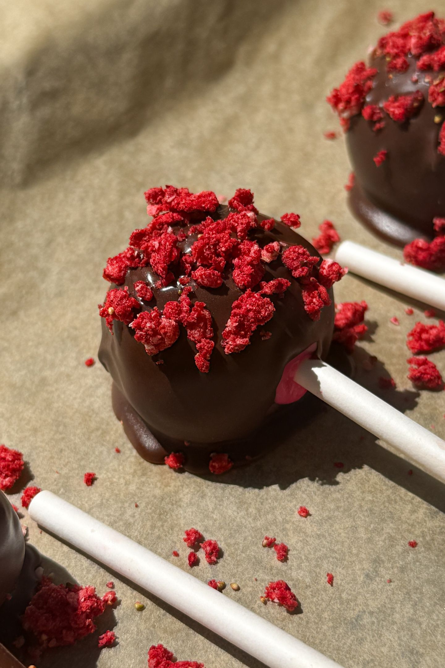 Strawberry Cake Pops on parchment paper.