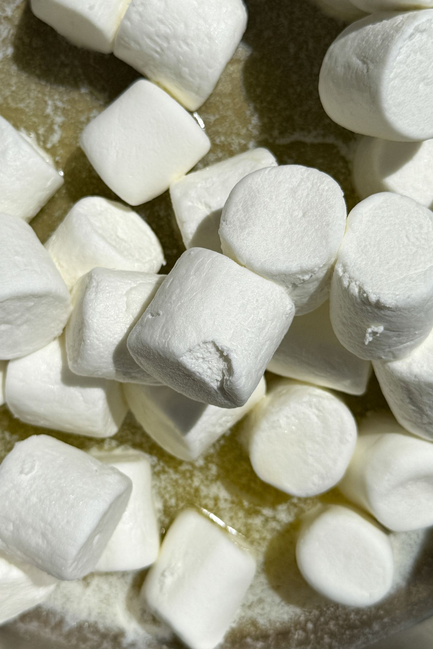 Melted butter in a pan with large marshmallows.