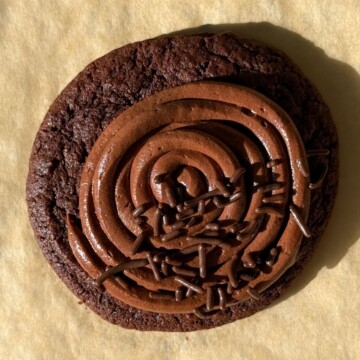 A soft chocolate cookie topped with a rich chocolate frosting and chocolate sprinkles.