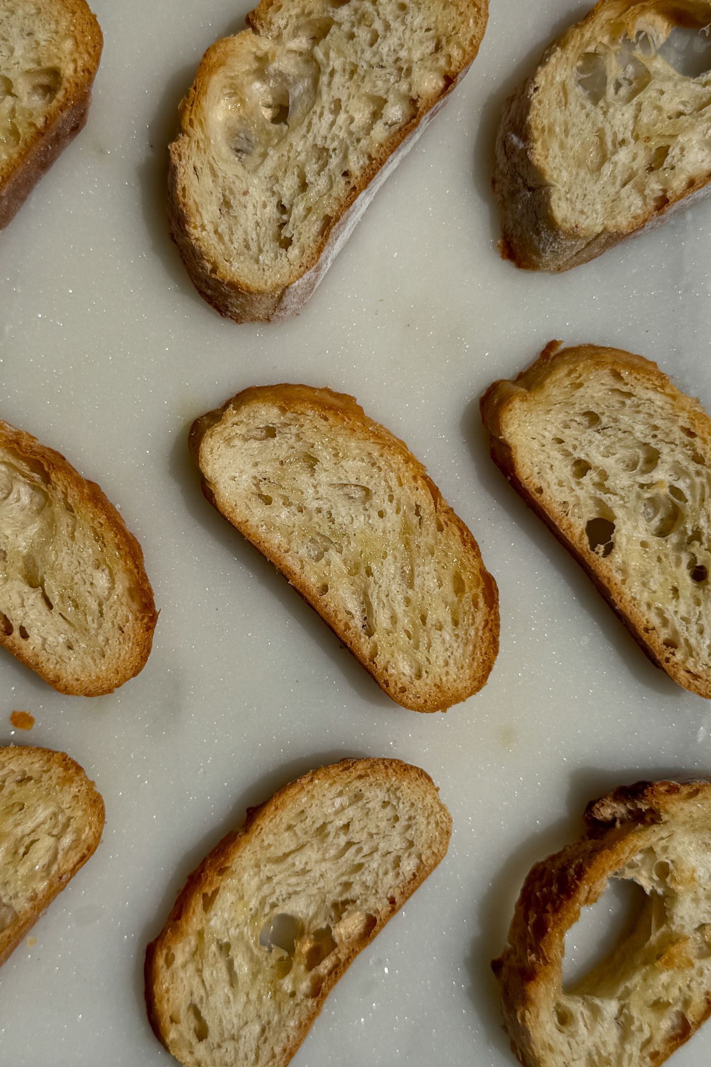 Baked crostini slices on a serving platter.