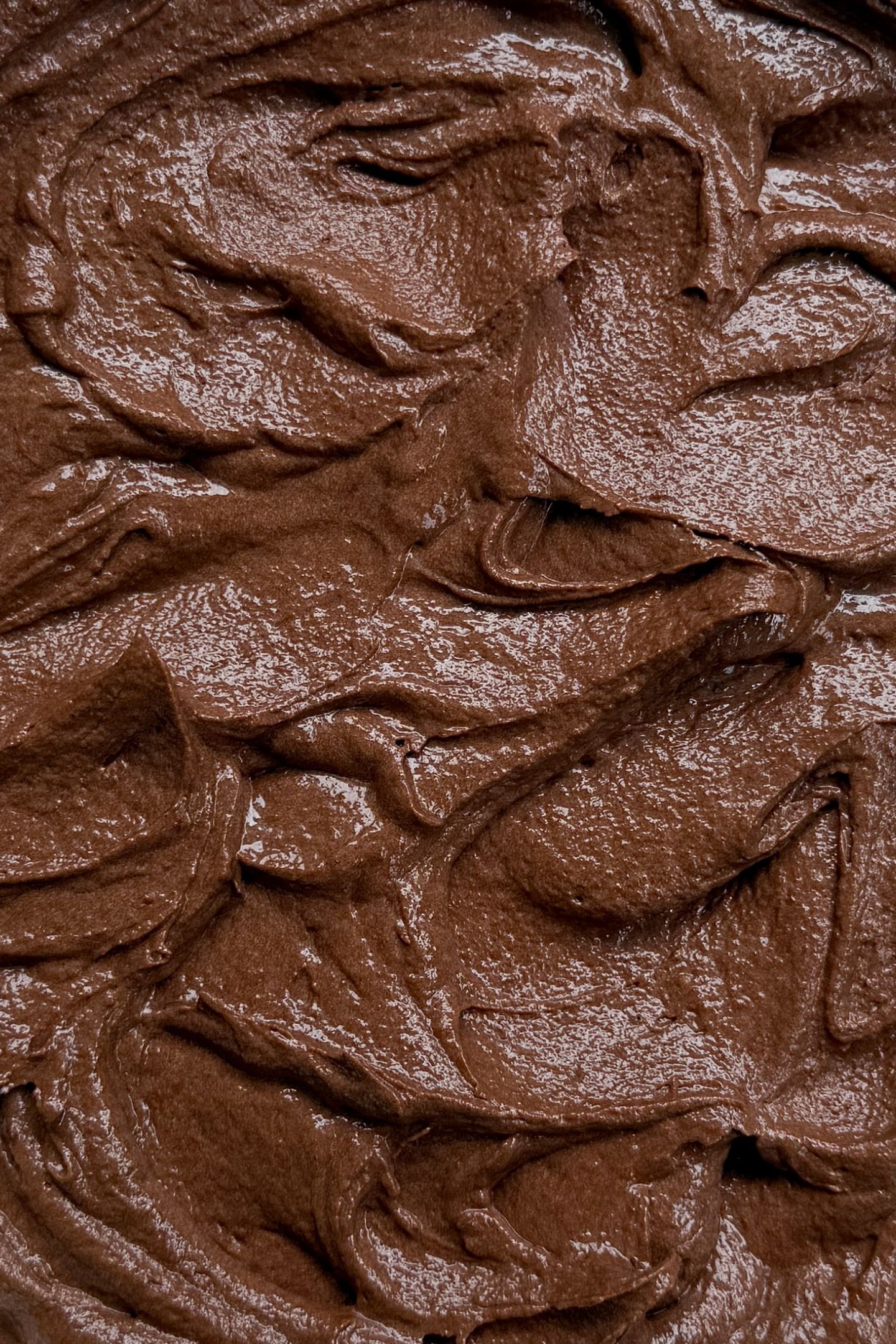 Chocolate buttercream frosting spread in a bowl.