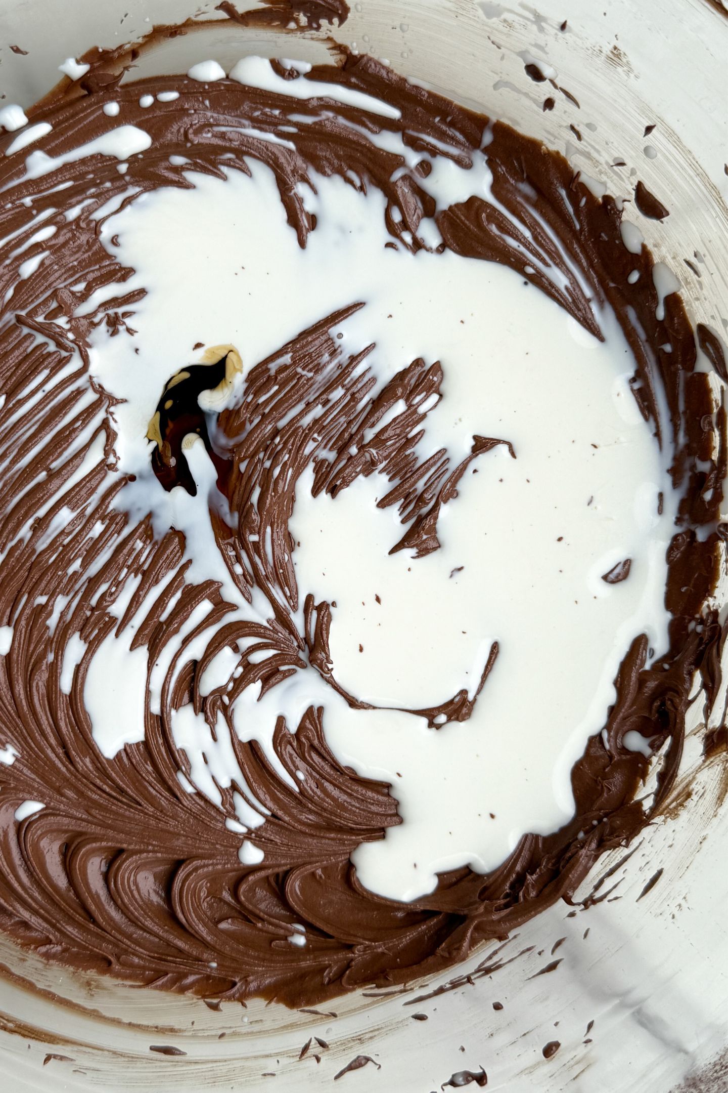 Heavy cream and vanilla extract being added to the mixture.