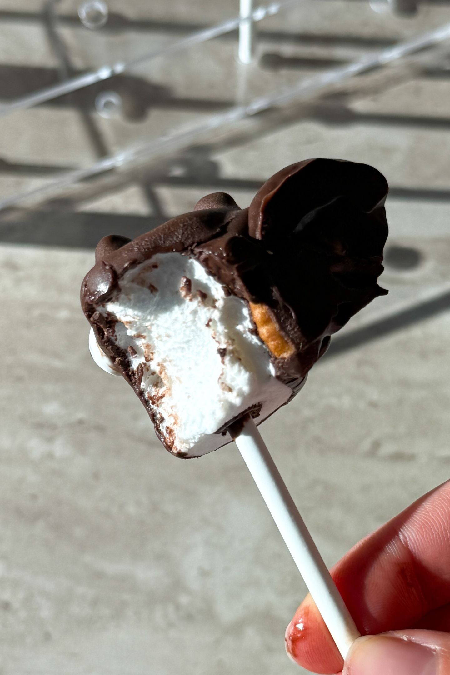A marshmallow pop with a bite taken out of it.