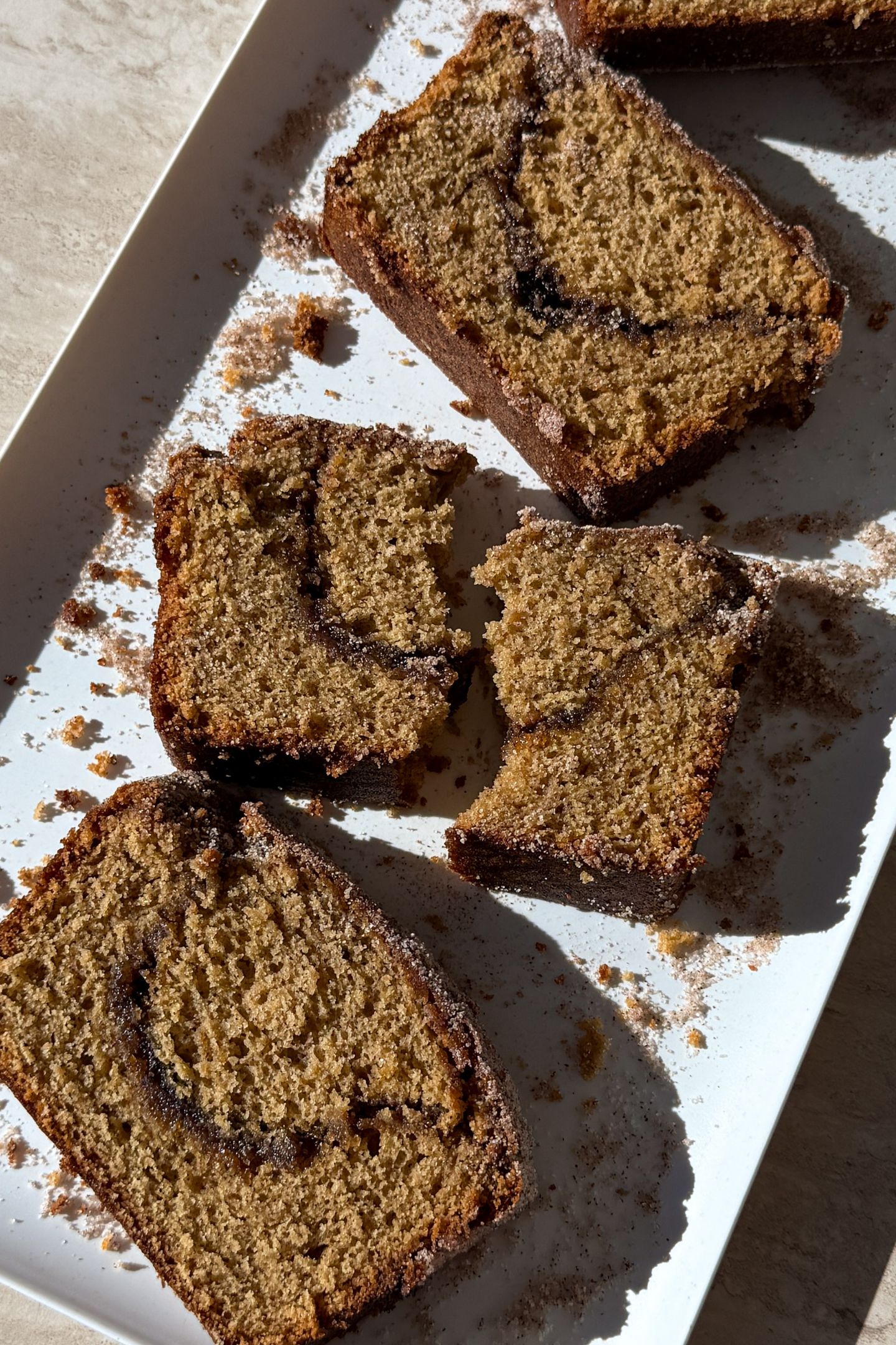A broke slice of apple donut bread on a platter.